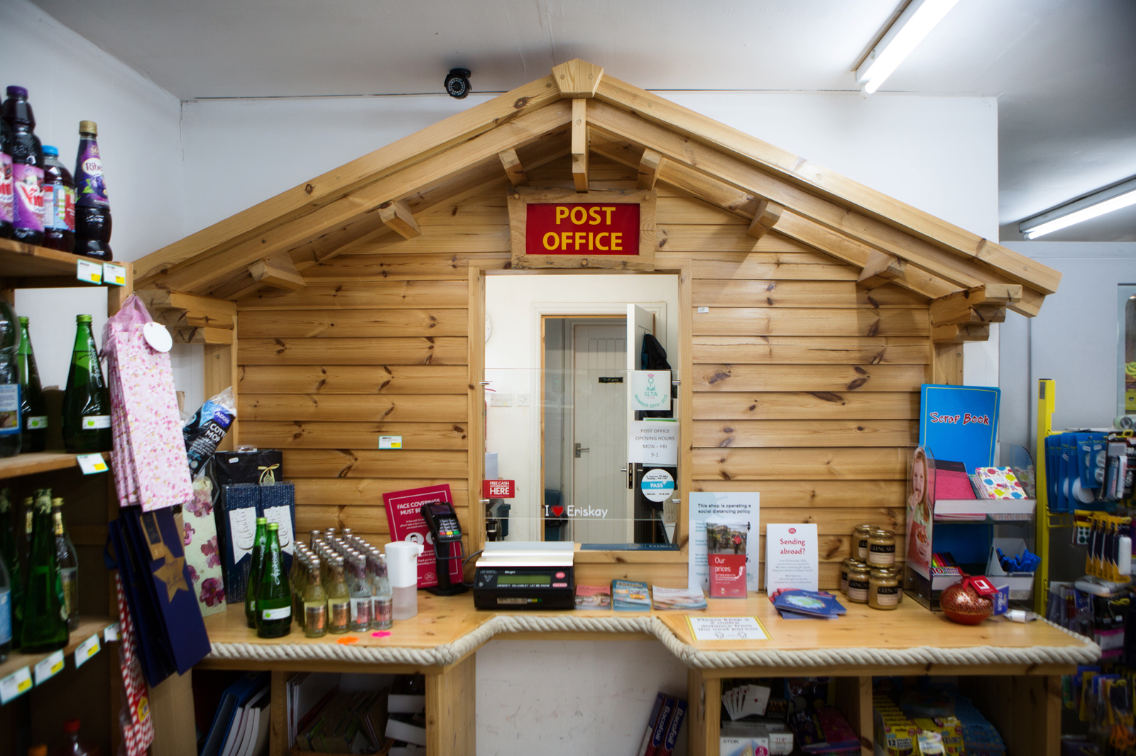 a post office counter that looks like a wooden shed, inside a local shop